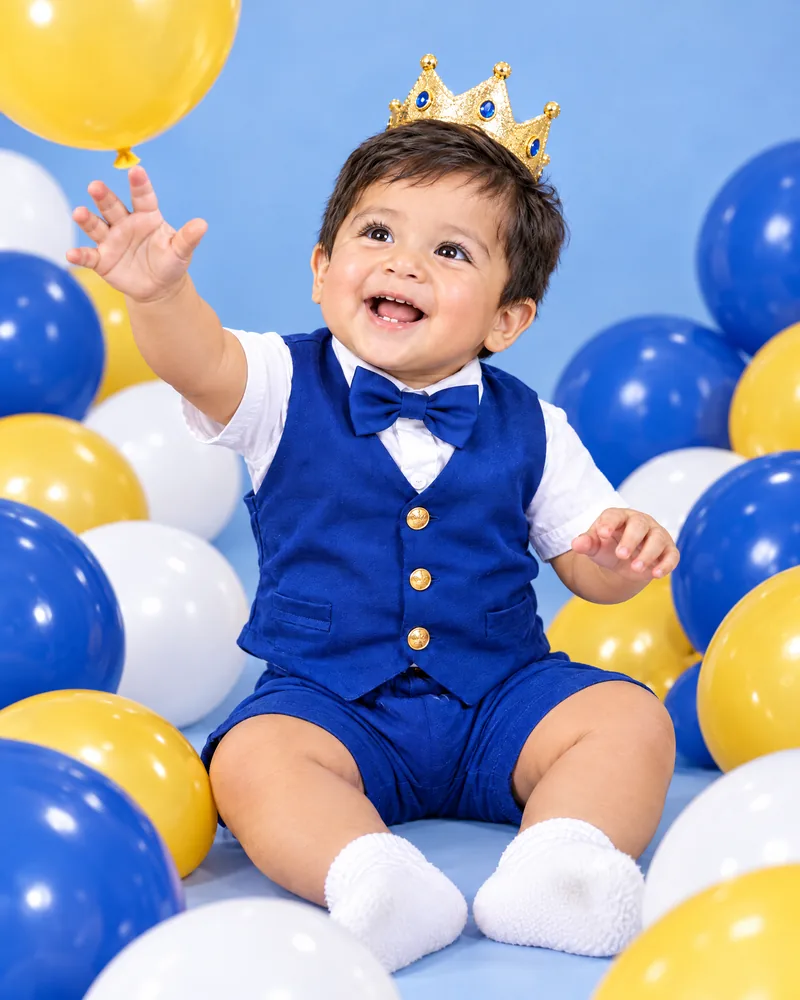 Mateo jugando entre globos azules, amarillos y blancos